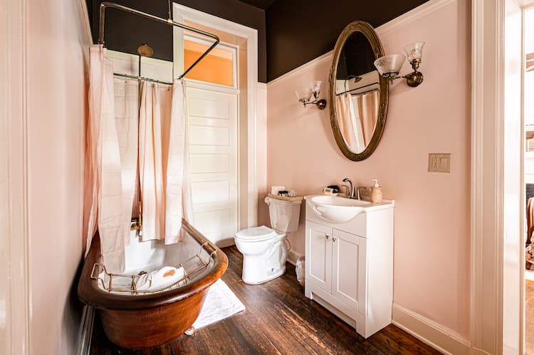 Wooden clawfoot tub with shower adorn the private bath