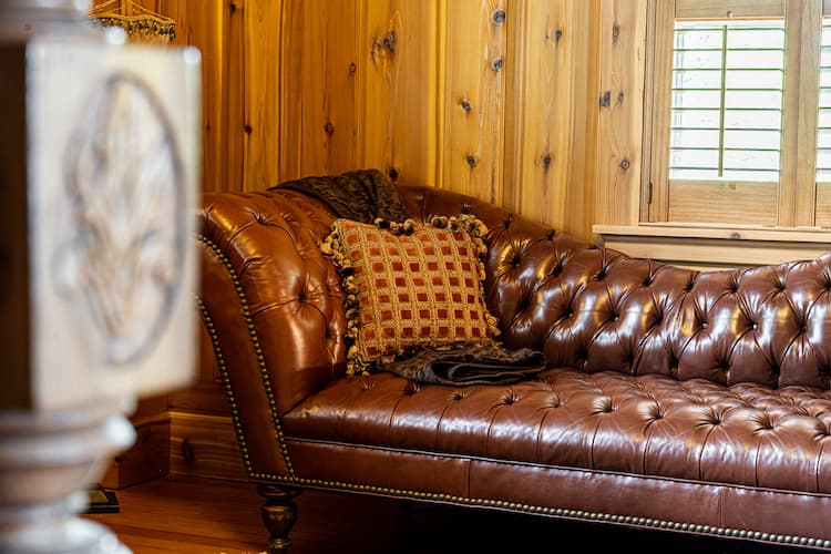 Rich brown leather chaise lounge opposite the bed