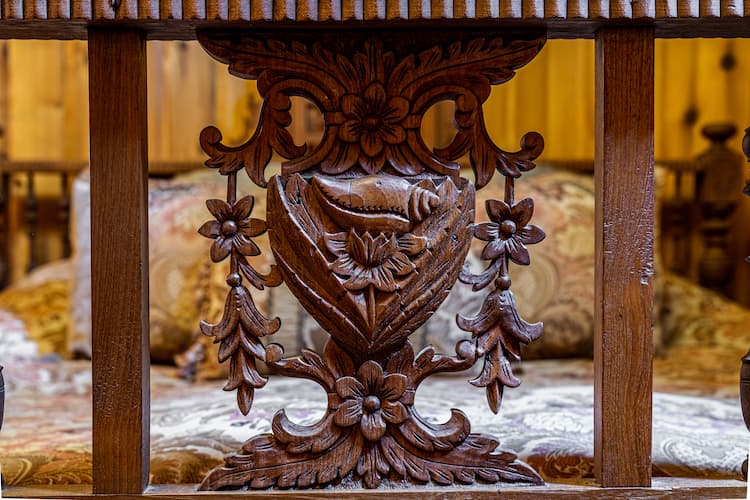 Ornately carved footboard detail on the wooden king size bed