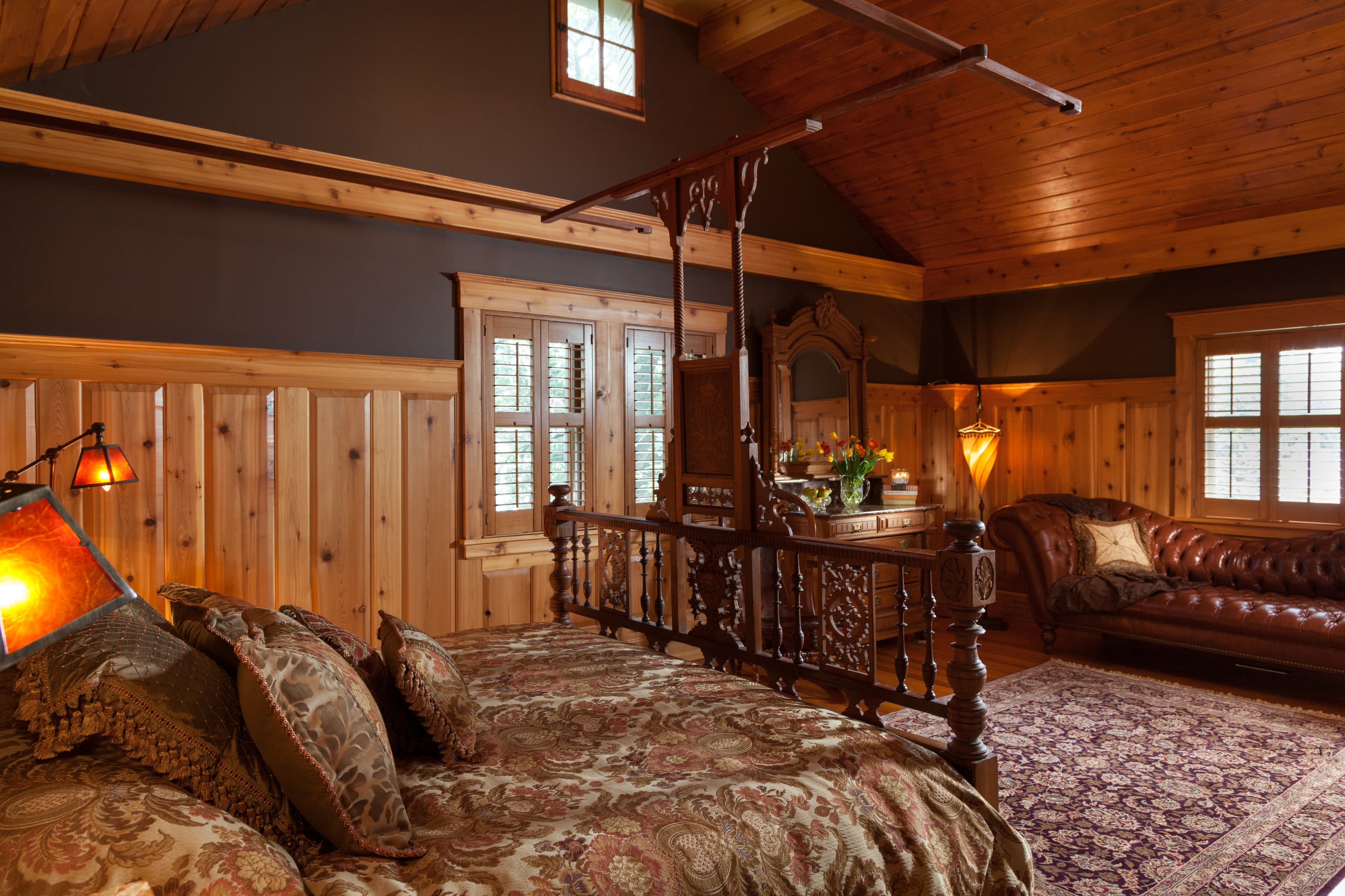 Larger of 2 suites in Carriage House with wood framed King Size Bed. Vaulted Ceiling with wood trim and shutter-blinds on east windows.