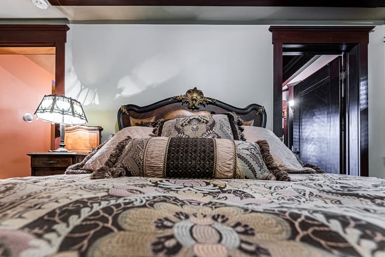 Close up of the queen size comforter and ornate headboard