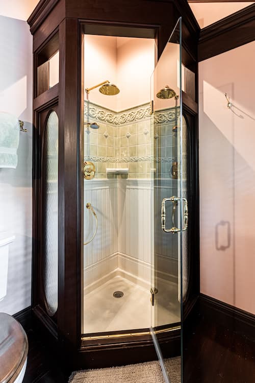 Stand up glass shower with dark wood accents