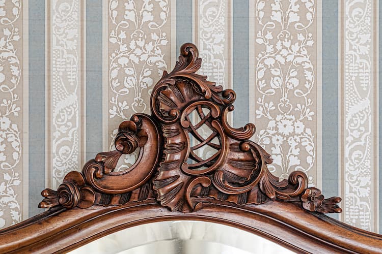 Ornamental scrollwork detail on the antique dresser next to the bathroom