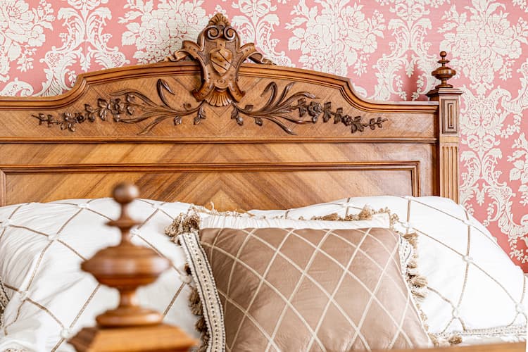 Close up of the queen size bed and ornamental headboard and footboard