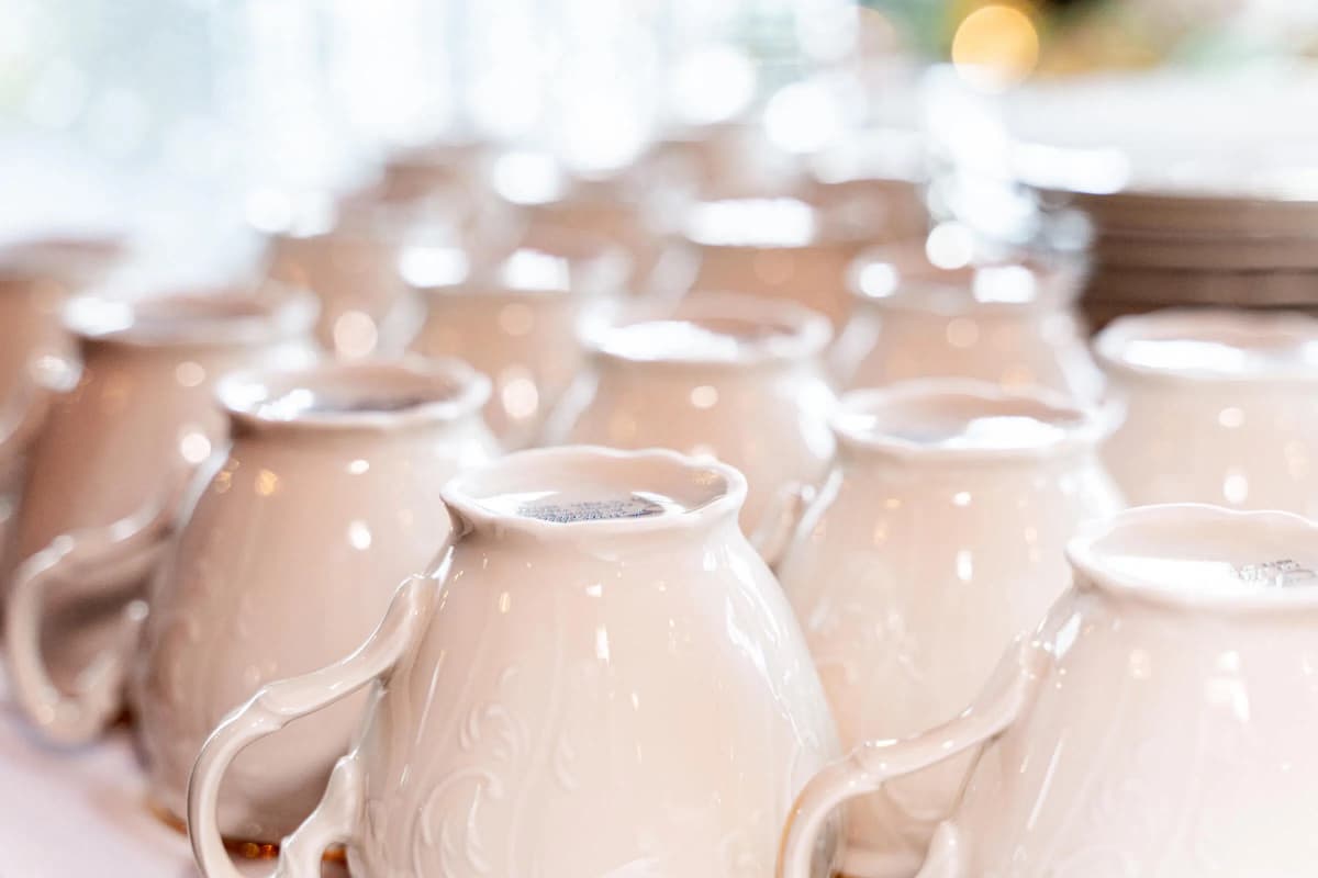 A row of elegant white porcelain teapots arranged neatly on a table.