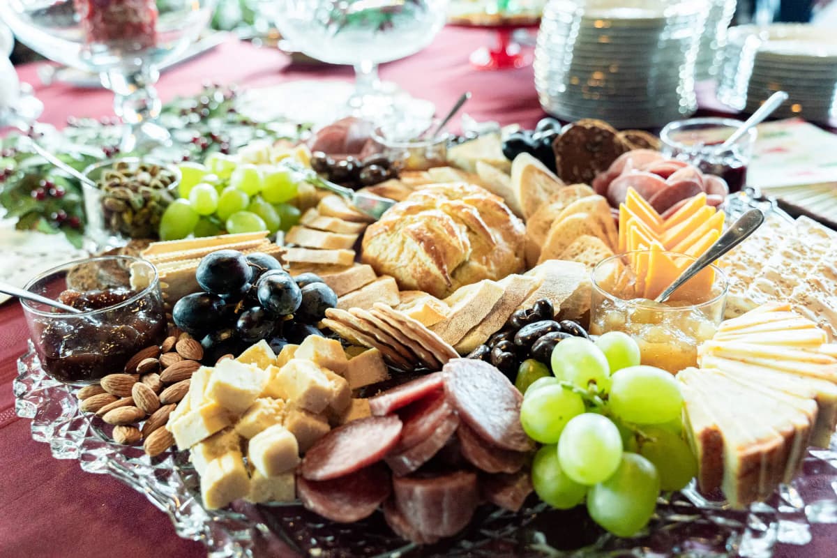 A beautifully arranged charcuterie board featuring various cheeses, meats, fruits, and nuts.