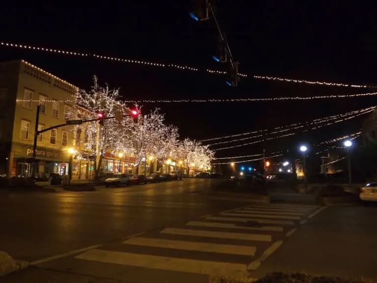 A vibrant street decorated with twinkling lights during the night.
