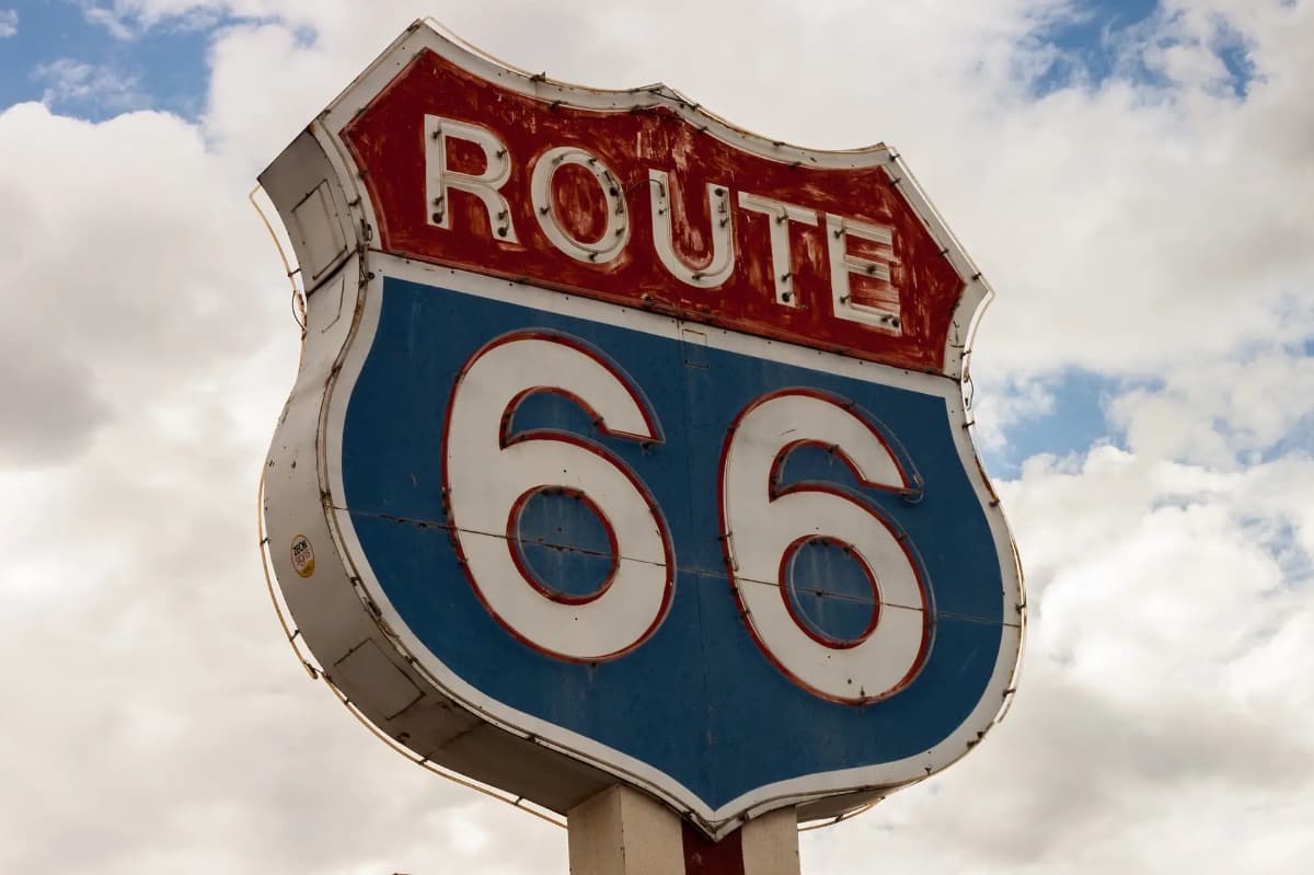 Sign for Route 66 against a cloudy sky. Sign for Route 66 against a cloudy sky.