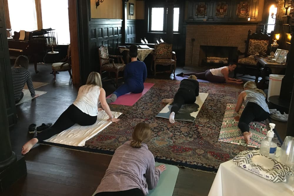 A group of people practicing yoga in a cozy, well-furnished room.