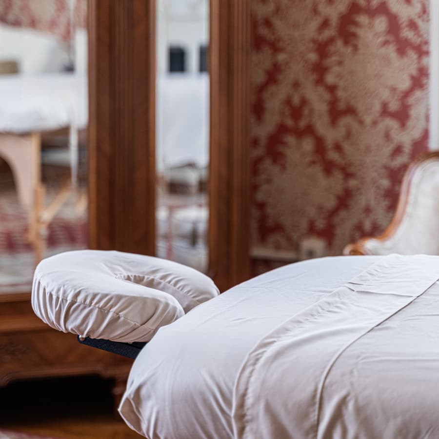 A close-up of a massage table in a warmly decorated room.