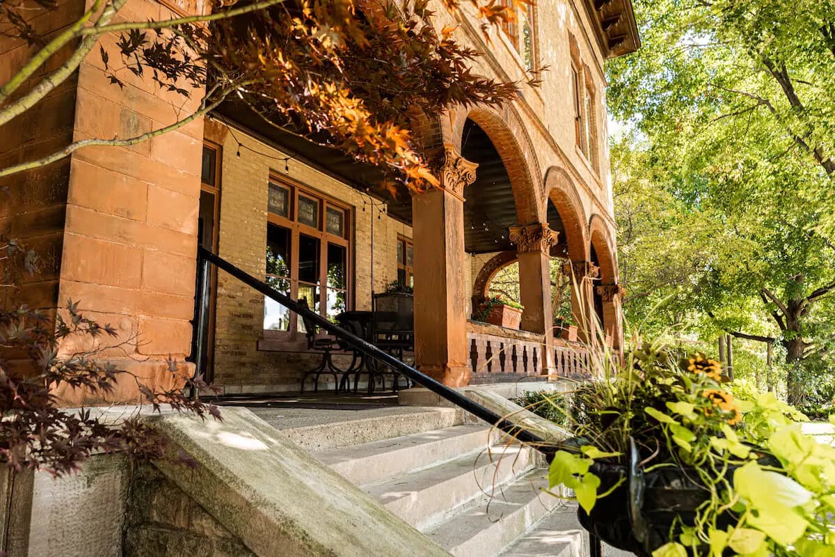 A historic brick building with arched entryways and a landscaped staircase.