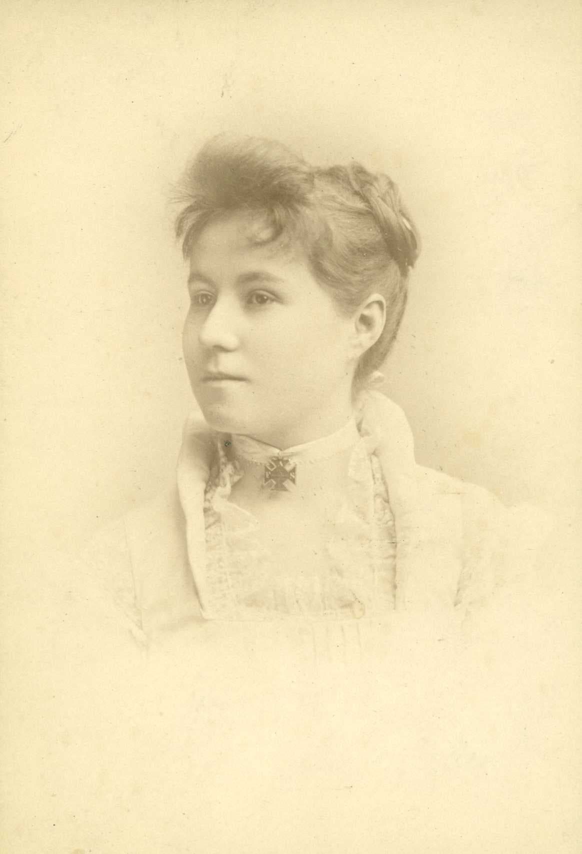 Black-and-white portrait of a young woman with a delicate hairstyle and a lace collar.
