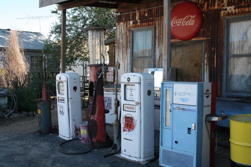 A rustic gas station with vintage pumps and a Coca-Cola sign.