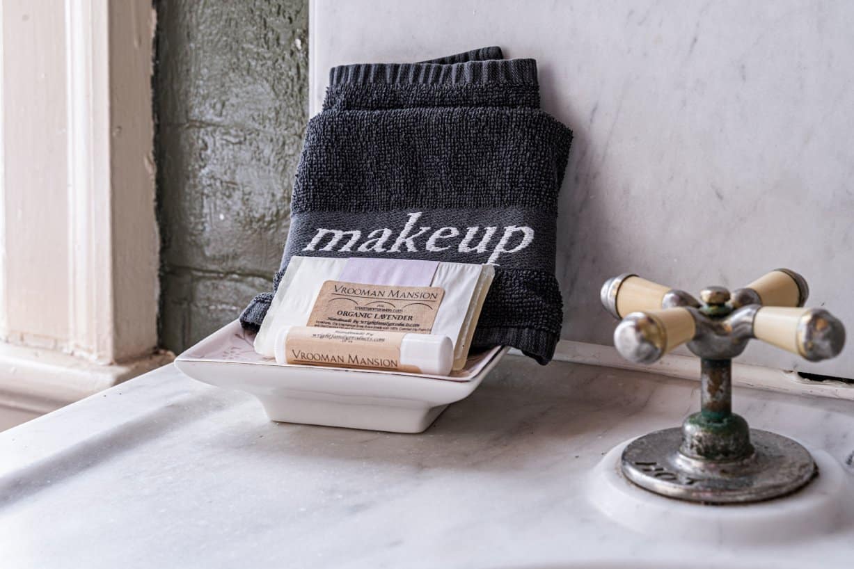 organic handsoap and lip balm next to a black makeup washcloth