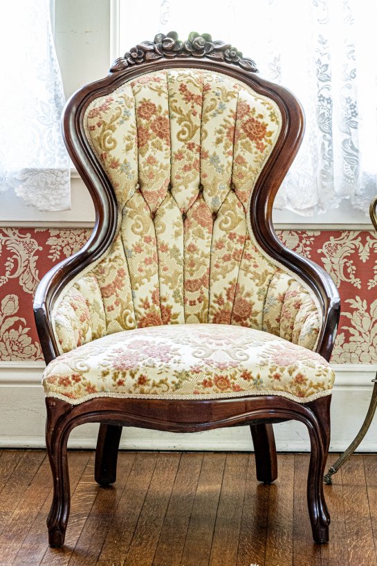 antique high back chair with a tufted flower pattern