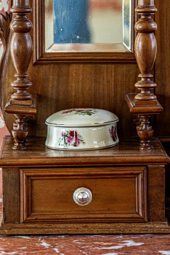 vintage powder canister on an antique dresser