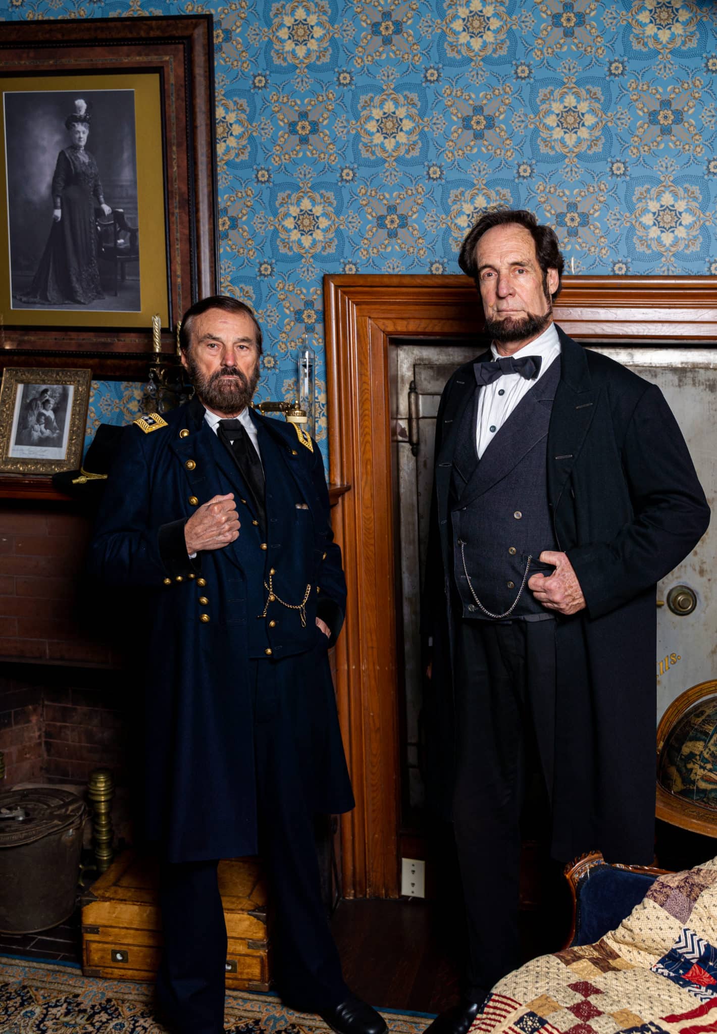 two men portraying US presidents Lincoln and Grant stand in front of a built-in wall safe
