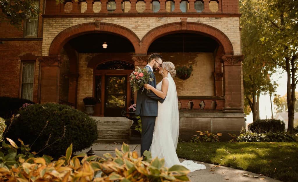 bride and groom share a moment in the fall on the front porch