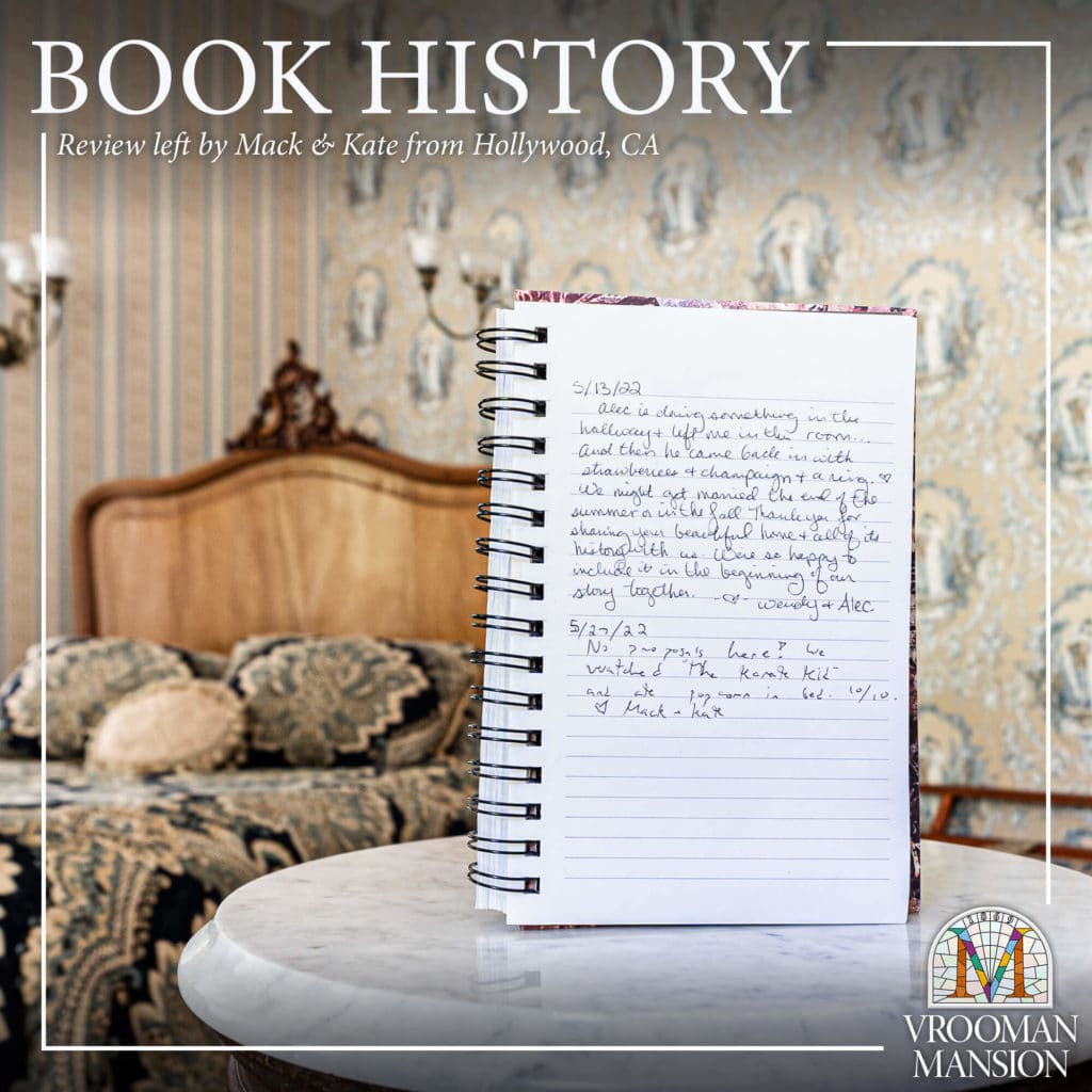 handwritten guest review in a journal on a white marble table with a queen sized bed in the background