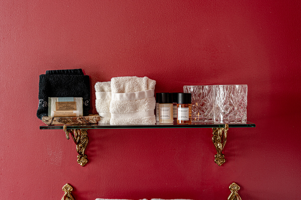 shampoo, conditioner, soap, washcloth and 2 glasses on a gold shelf