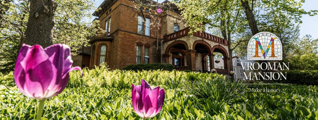 Vrooman Mansion from the front in the spring with purple tulips
